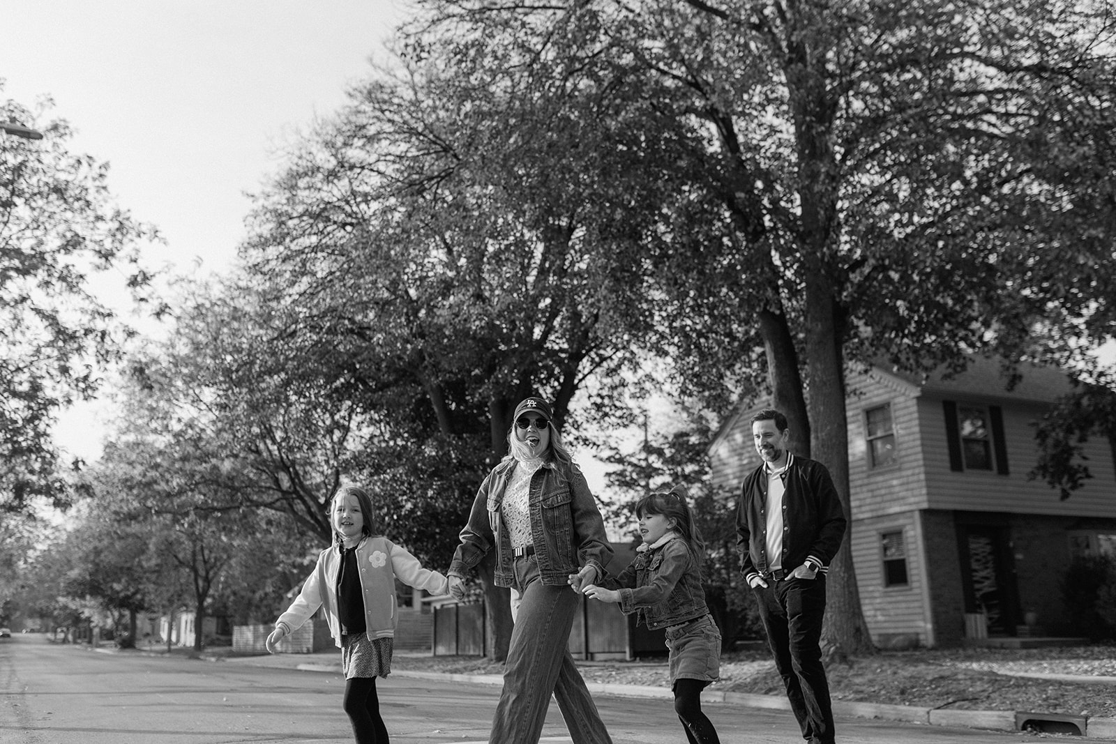 family holding hands and walking across the street